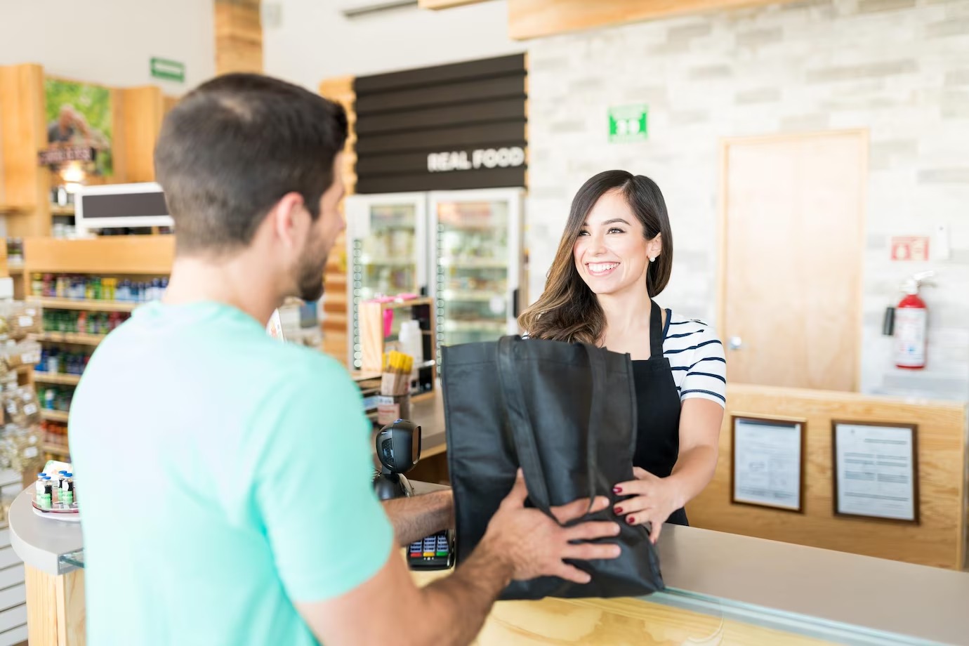 cajera confiada dando bolsa joven mostrador pago supermercado 662251 1429
